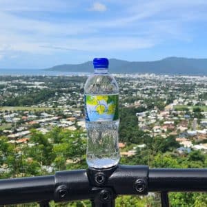 Water bottle on fence railing with view over cairns in the background